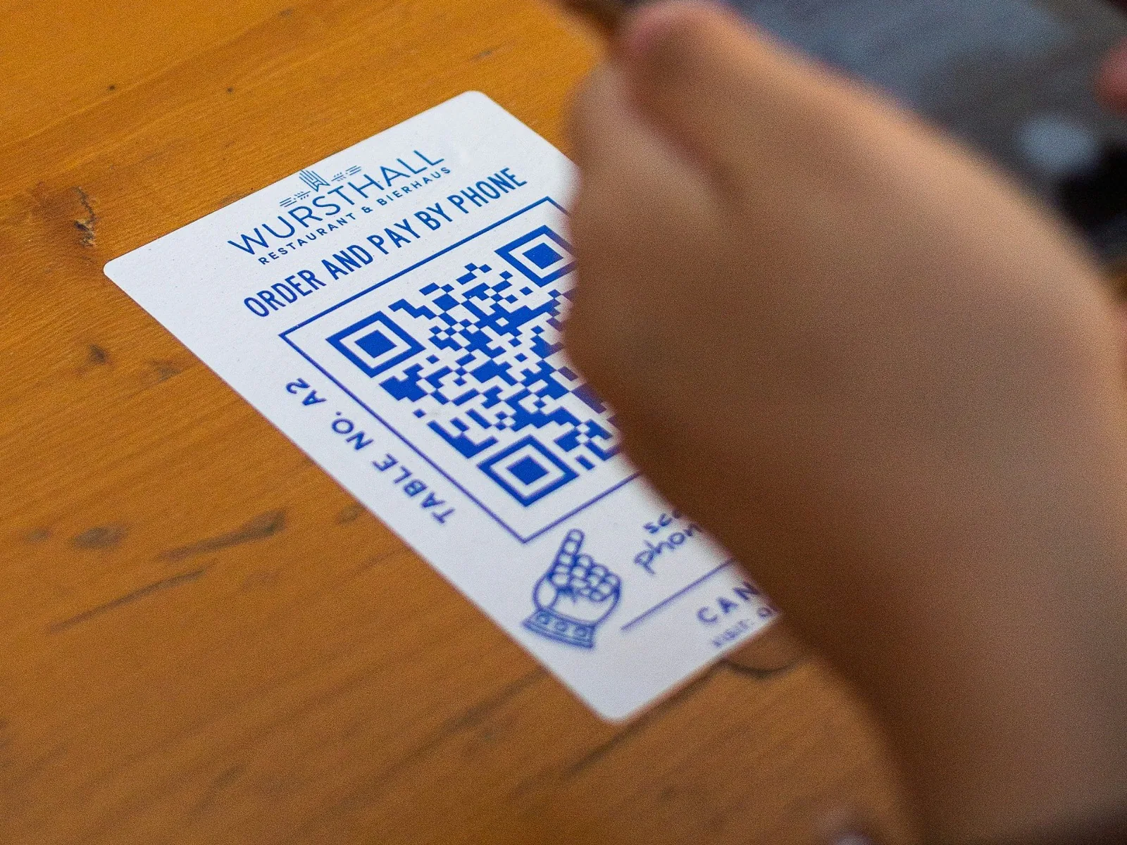 Information card with a QR code being scanned in a hospitality setting.