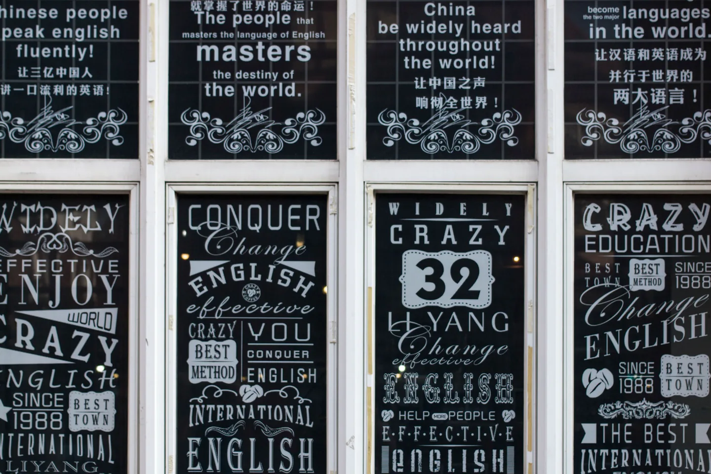 Large-format typographic graphics installed across a commercial glazed facade.
