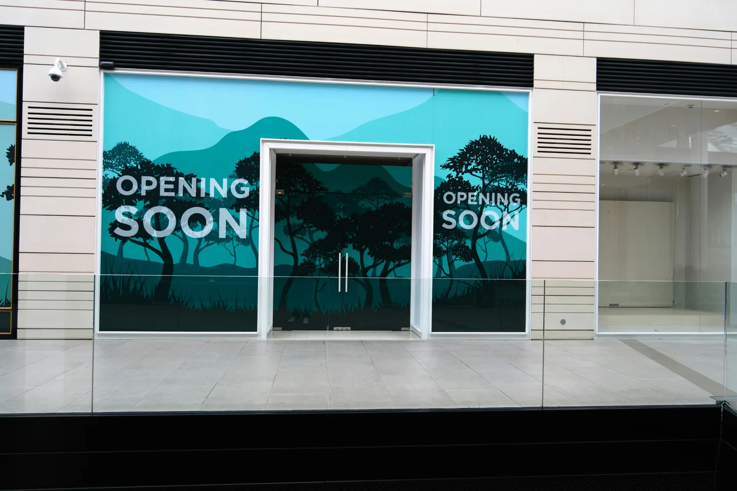 Large-format window graphics covering a commercial storefront ahead of opening.