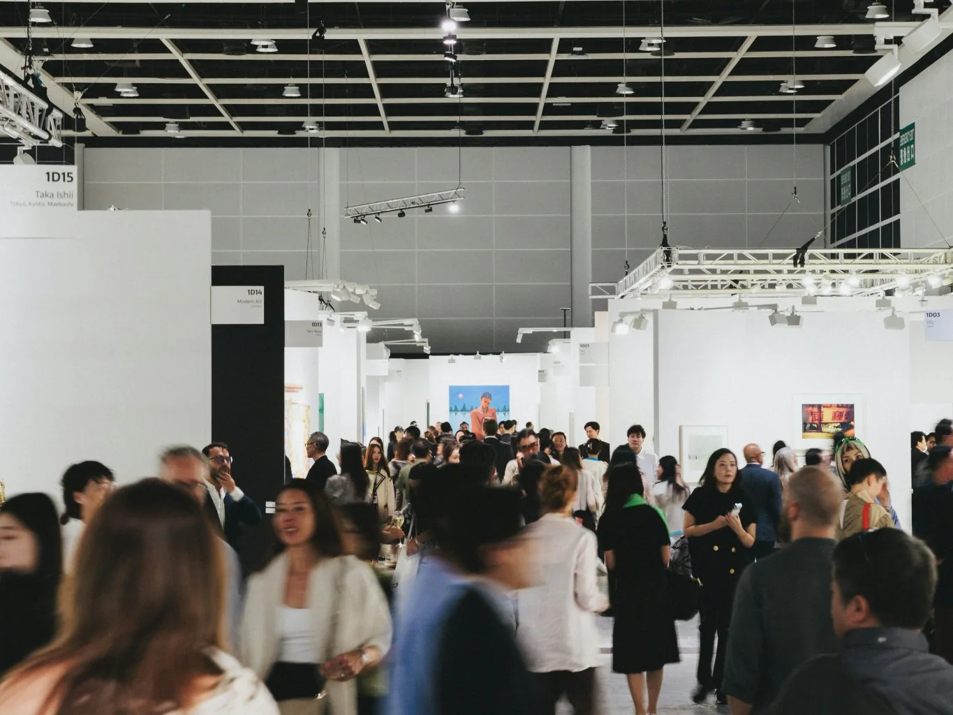 Busy exhibition environment with visitors moving through built display spaces.