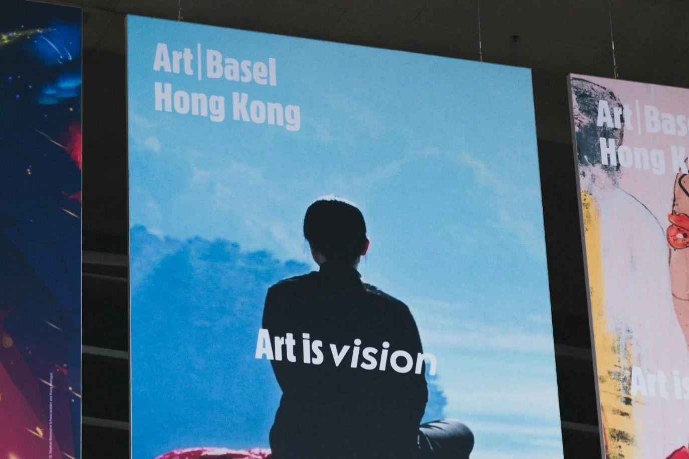 Large suspended printed fabric panels at an exhibition.