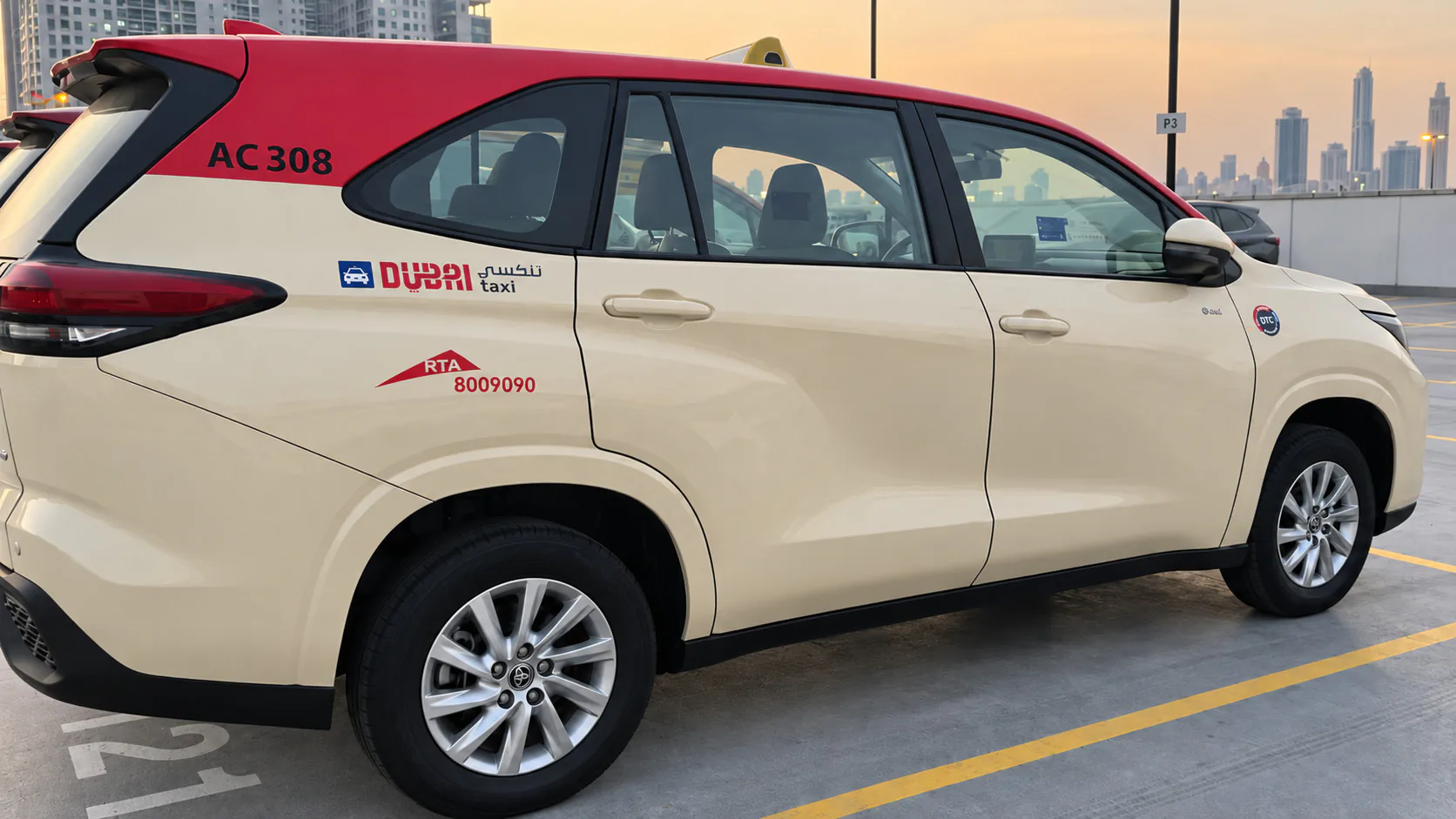 Dubai Taxi in red and cream fleet livery, side view, with door graphics and fleet number applied.