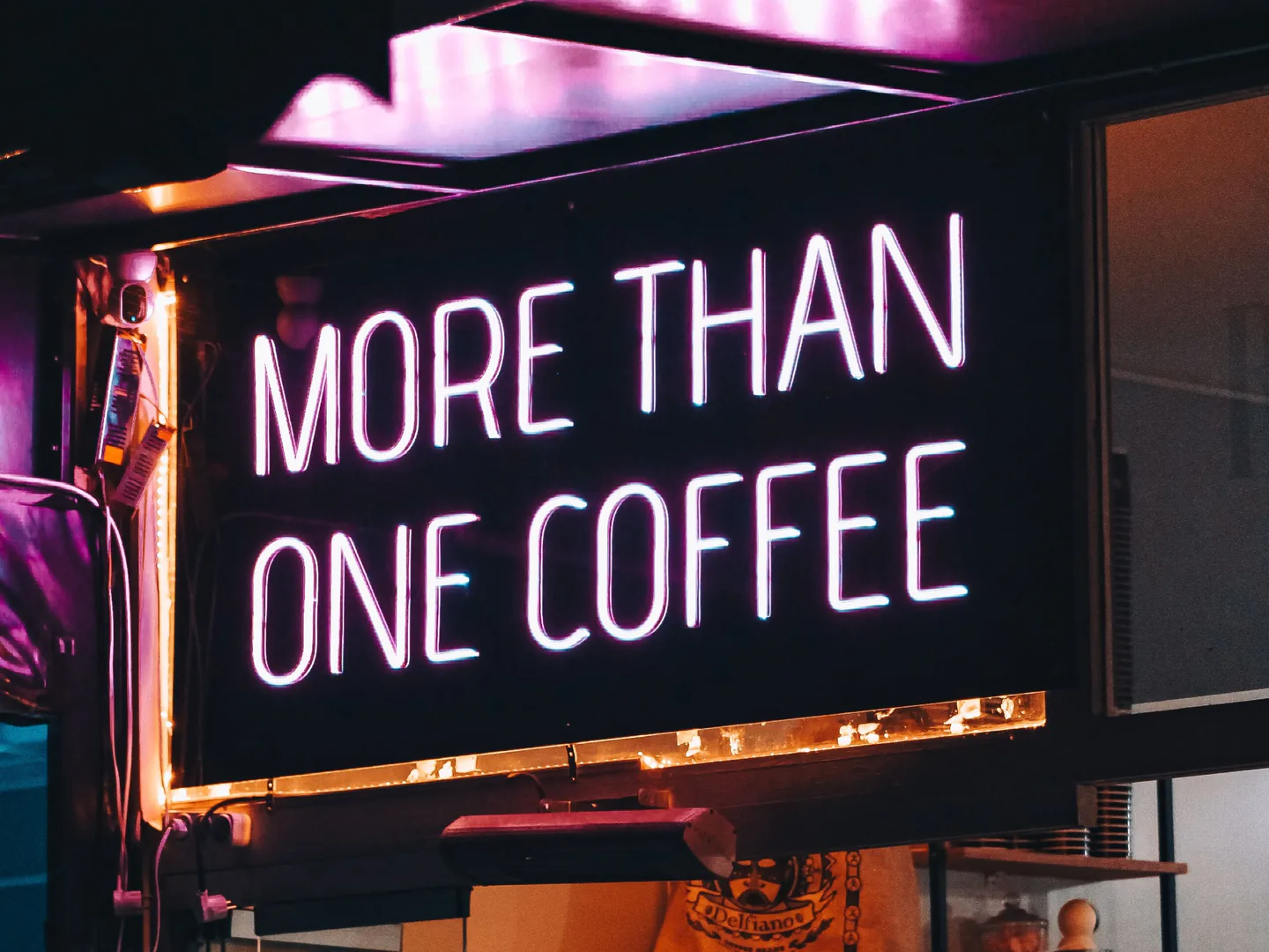 Illuminated commercial sign reading More Than One Coffee, demonstrating high-visibility signage.