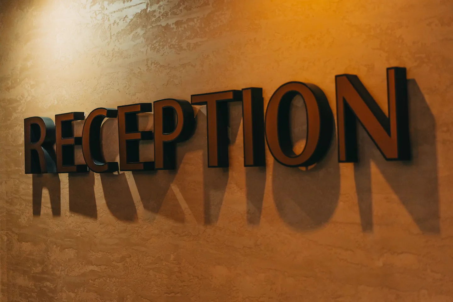 Dimensional reception lettering installed on a warm interior wall.